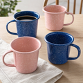 Cobalt and blush speckled enamel mugs on a table