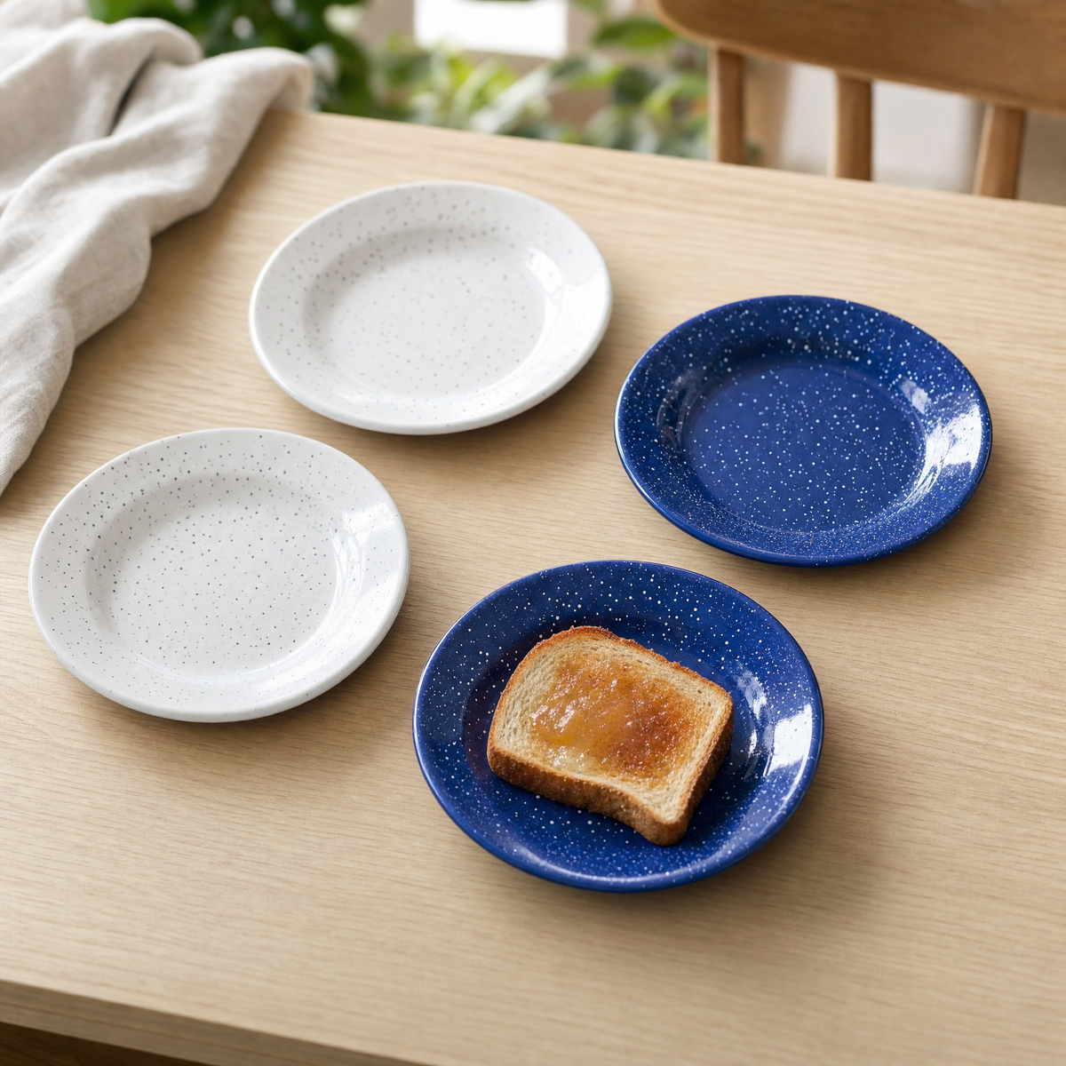 White and cobalt speckled enamel side plates, one with toast