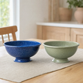 Cobalt and sage speckled enamel footed bowls on a table